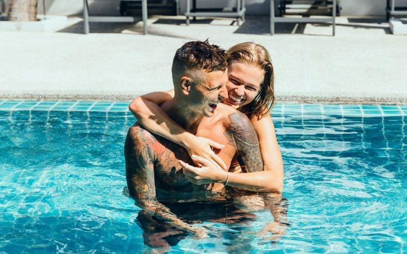 a man and woman hugging in a pool